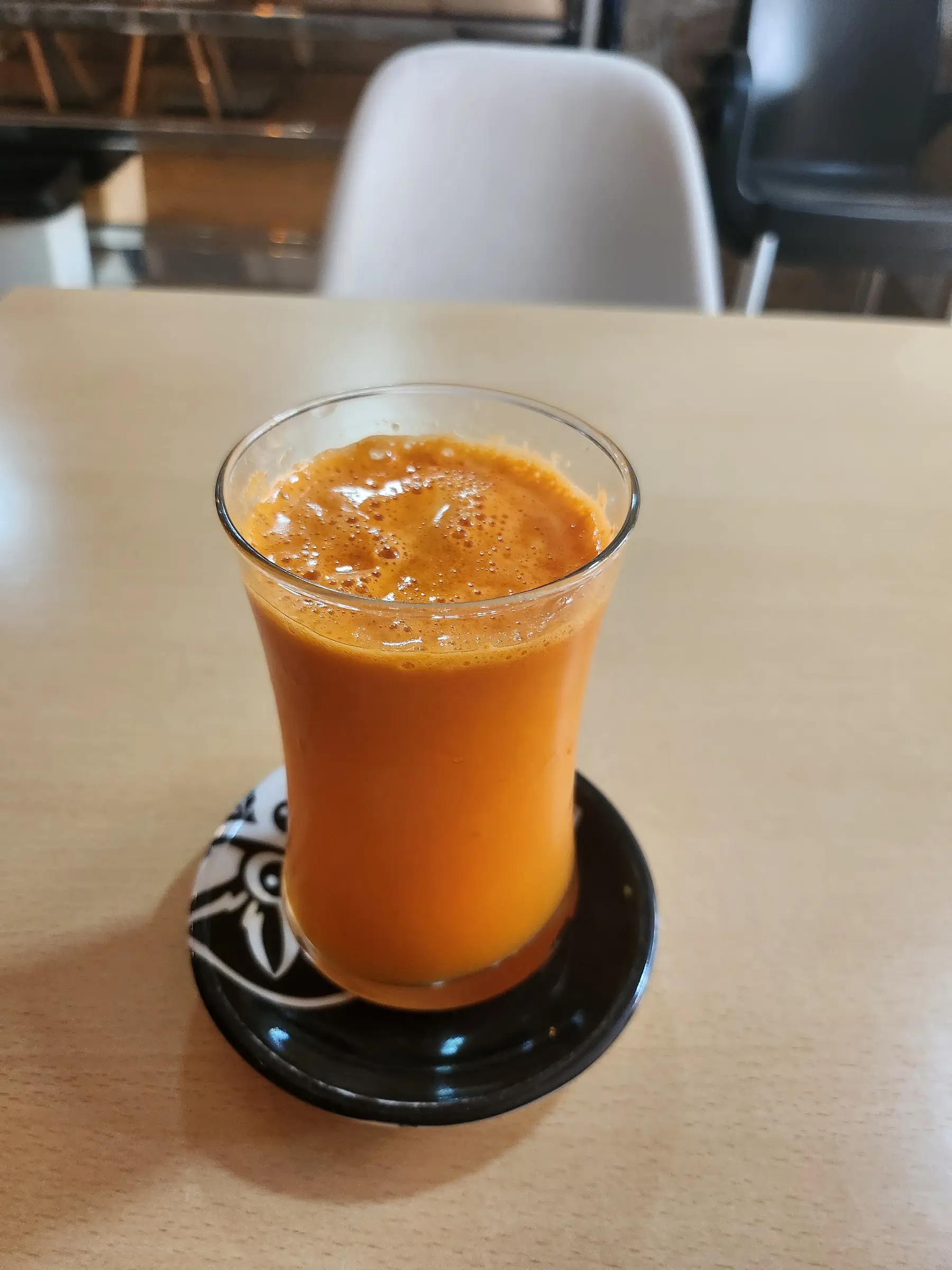 Zumo natural en un vaso de tulipa sobre un posavasos negro